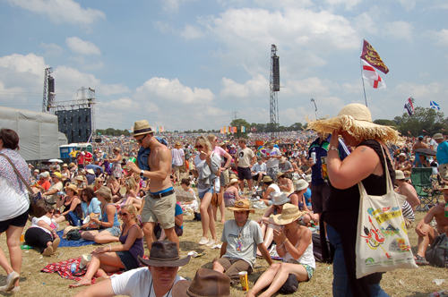 A festival crowd of music fans gathers by the Pyramid Stage at Glastonbury Festival , UK
